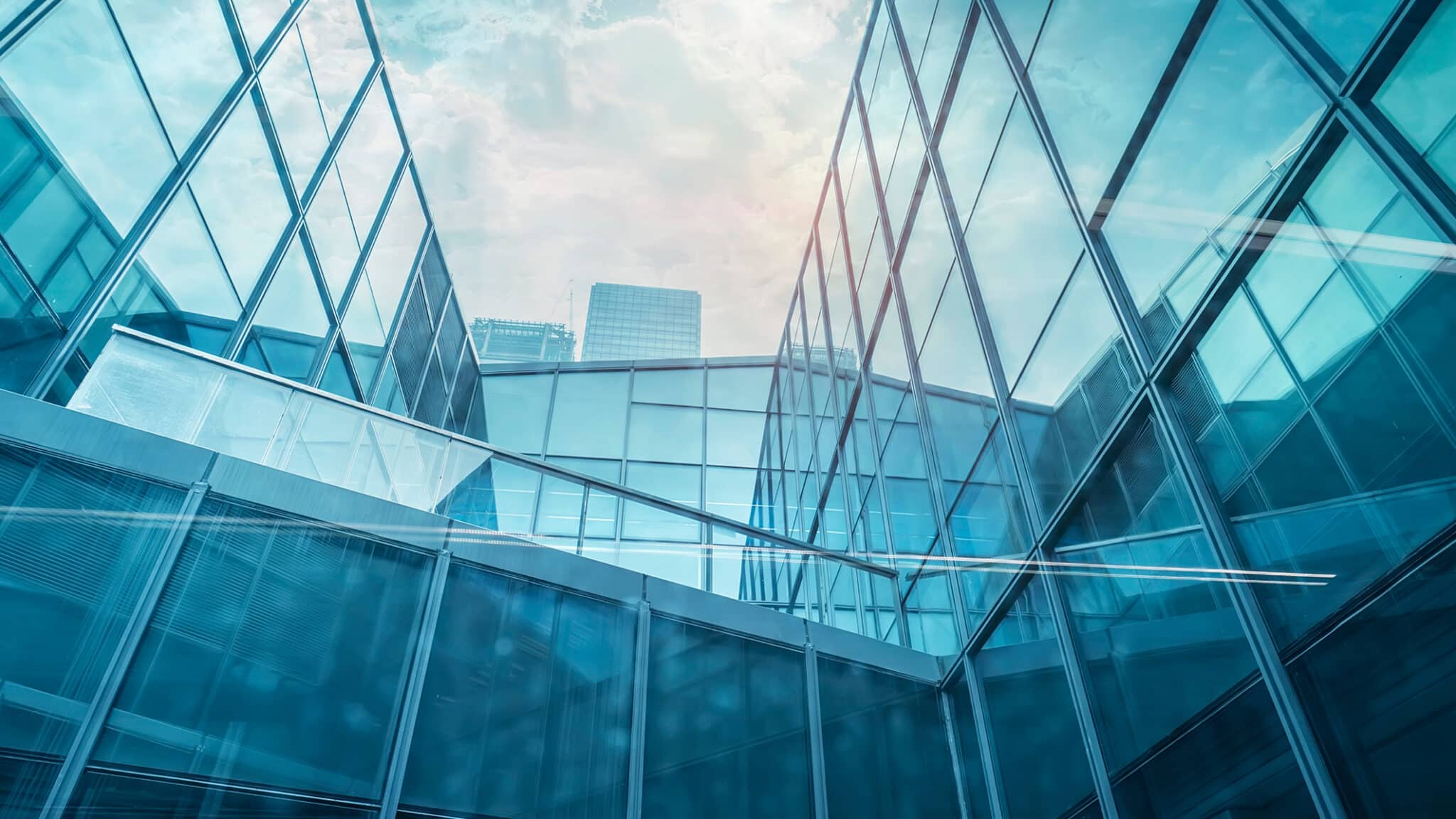 Blick auf moderne Gebäude mit großen Glasflächen und reflektierenden Oberflächen.